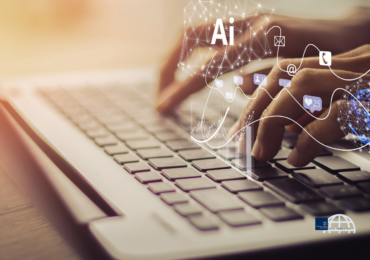 Hands typing on a laptop with futuristic AI technology overlays, digital networks, graphs and icons – Exploring AI and tech trends in mid-2026 | Radeya Global
